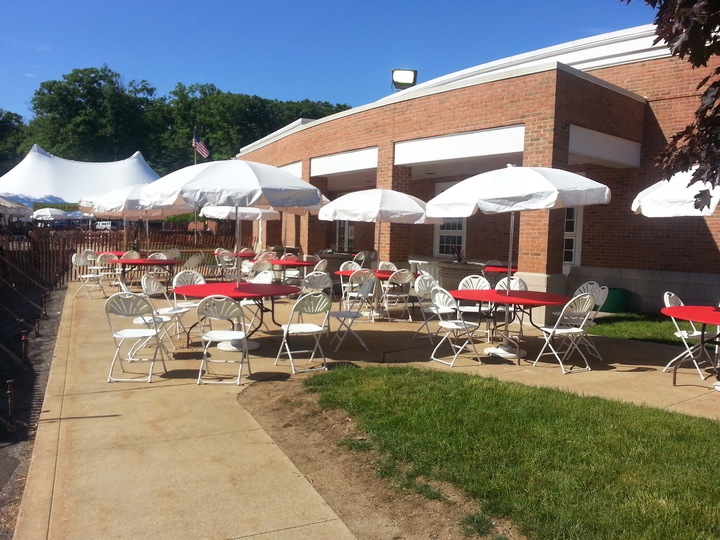 Outdoor academic event with multiple umbrellas and seating