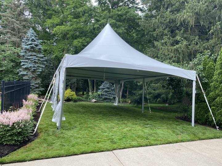 Peak tent setup in landscaped garden setting
