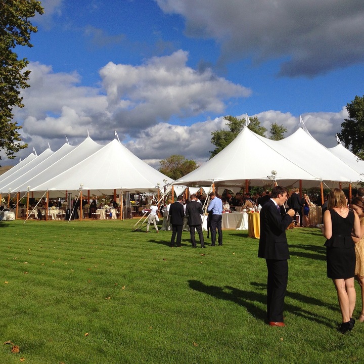 Multiple sailcloth tents at outdoor wedding celebration